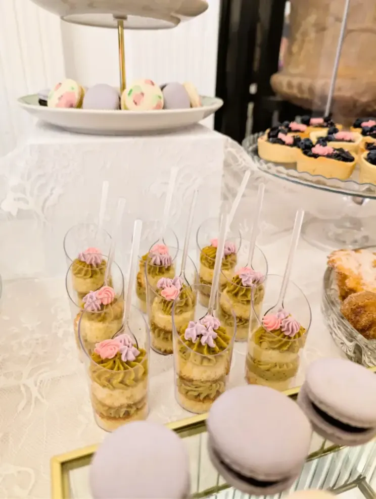 Bakery Corner de boda con vasitos de bizcocho y crema de pistacho, macarons, tartaletas de arándanos y minipostres, montado por Magda Sweet Cakes en Granada.